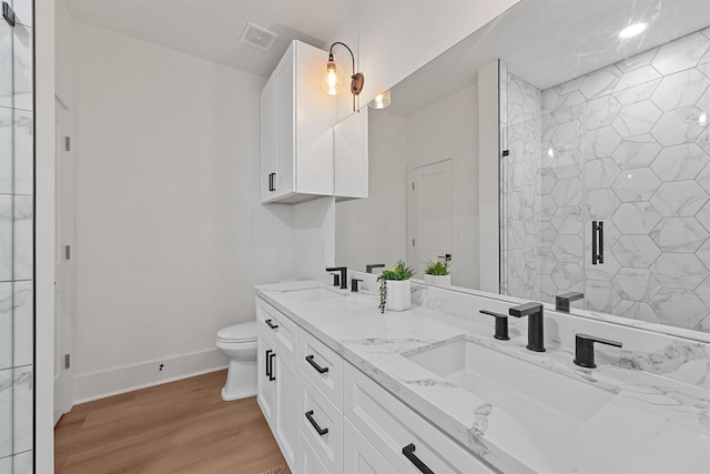 21330 Scissor Tail Ln, Galveston, TX 77554 - full bathroom with double vanity, wood finished floors, and a shower stall