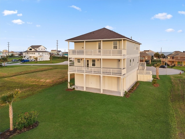 21330 Scissor Tail Ln, Galveston, TX 77554 - rear view of house with a yard, a balcony, a residential view, and a shingled roof