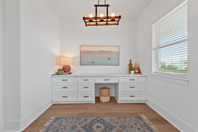 21330 Scissor Tail Ln, Galveston, TX 77554 - home office with built in desk, a chandelier, and light wood finished floors