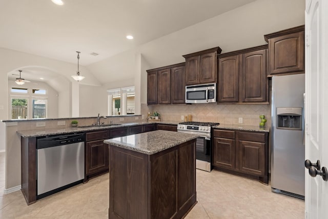 4211 Ponderosa Hills Ln, Katy, TX 77494 - kitchen featuring stainless steel appliances, tasteful backsplash, a peninsula, dark brown cabinets, and light stone counters