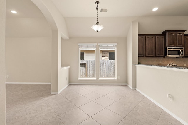 4211 Ponderosa Hills Ln, Katy, TX 77494 - unfurnished dining area featuring light tile patterned floors, arched walkways, and recessed lighting