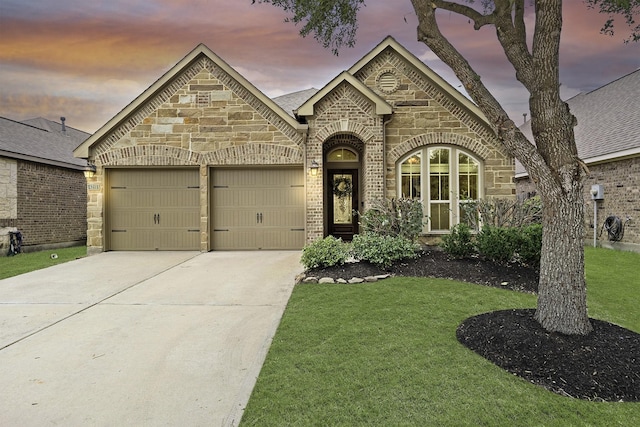 4211 Ponderosa Hills Ln, Katy, TX 77494 - french country inspired facade with stone siding, a garage, concrete driveway, a yard, and brick siding