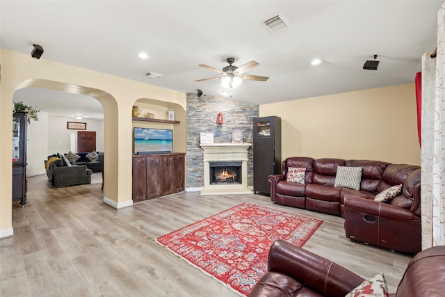 7622 Crestbrook Manor Ln, Cypress, TX 77433 - living room featuring a ceiling fan, arched walkways, wood finished floors, a stone fireplace, and recessed lighting