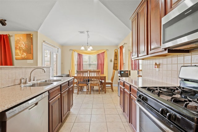 7622 Crestbrook Manor Ln, Cypress, TX 77433 - kitchen featuring appliances with stainless steel finishes, lofted ceiling, light countertops, light tile patterned floors, and backsplash