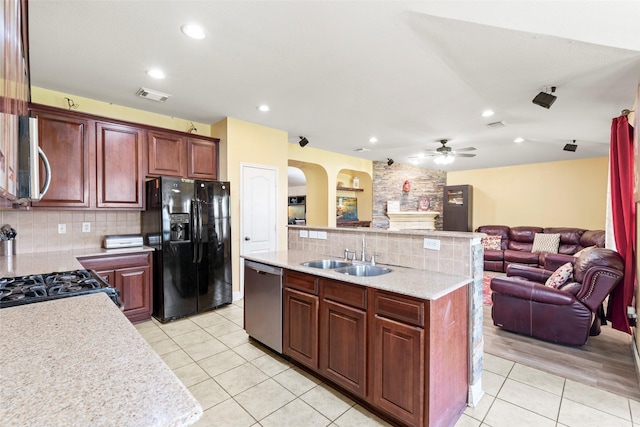 7622 Crestbrook Manor Ln, Cypress, TX 77433 - kitchen with stainless steel appliances, light tile patterned floors, open floor plan, backsplash, and arched walkways