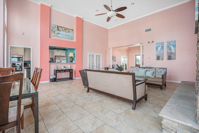 7000 Seawall Blvd Unit 611, Galveston, TX 77551 - living area featuring ceiling fan, a towering ceiling, crown molding, and decorative columns