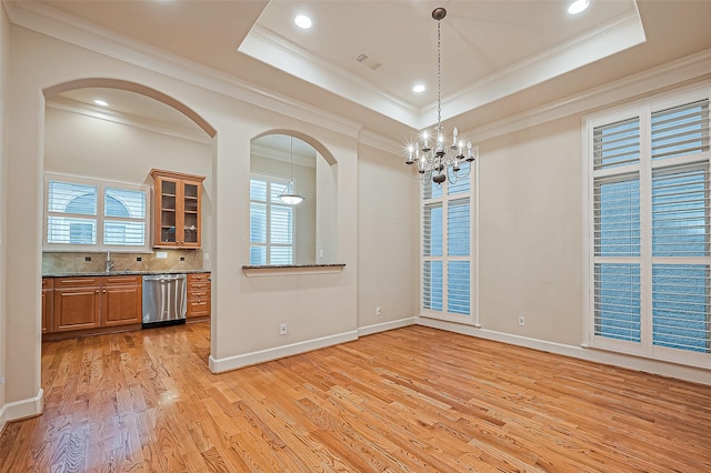 2616 Helena St, Houston, TX 77006 - unfurnished dining area with a chandelier, light wood-style floors, arched walkways, ornamental molding, and a tray ceiling