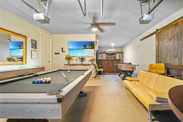 13526 Wedgewood Thicket Way, Cypress, TX 77429 - playroom with billiards, a barn door, a ceiling fan, and finished concrete flooring