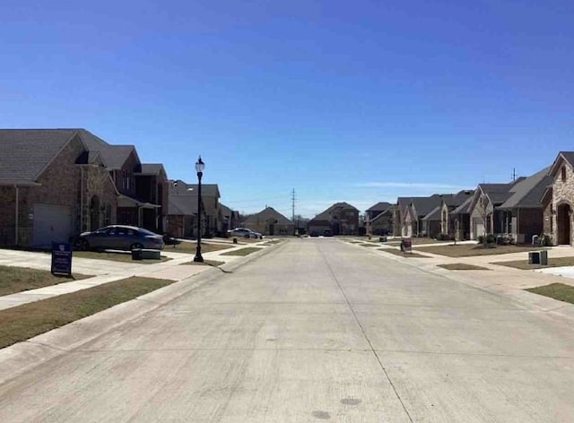 2920 Brady Starr Dr, Aubrey, TX 76227 - view of concrete road with a residential view, street lighting, curbs, and sidewalks