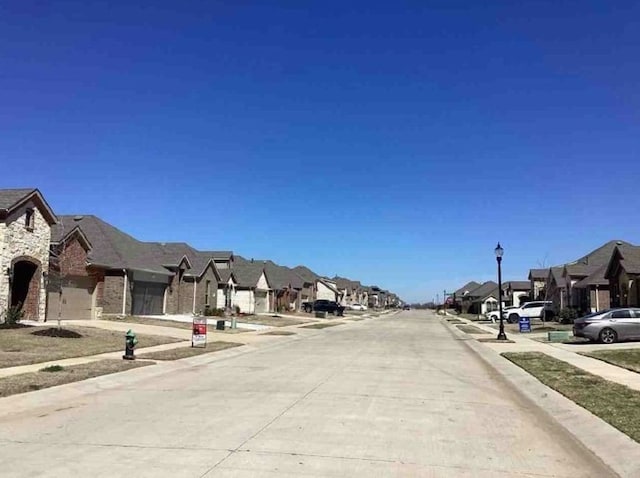 2920 Brady Starr Dr, Aubrey, TX 76227 - view of concrete road featuring a residential view, street lighting, curbs, and sidewalks