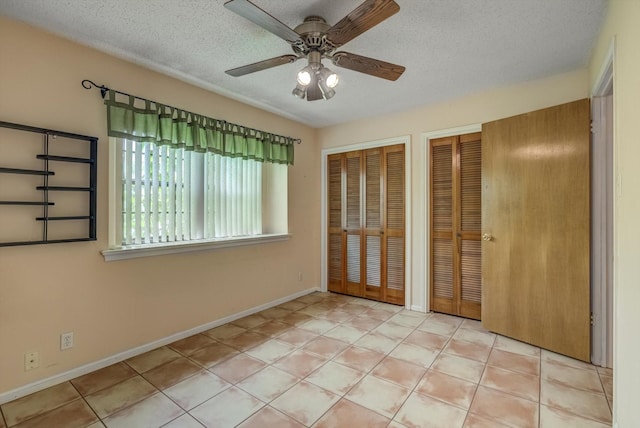 414 Daffodil St, Lake Jackson, TX 77566 - unfurnished bedroom with multiple closets, a textured ceiling, and ceiling fan