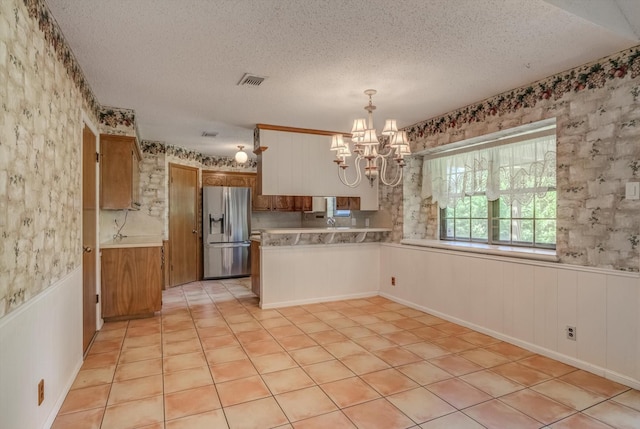 414 Daffodil St, Lake Jackson, TX 77566 - kitchen with stainless steel fridge with ice dispenser, a textured ceiling, a chandelier, wainscoting, and light countertops