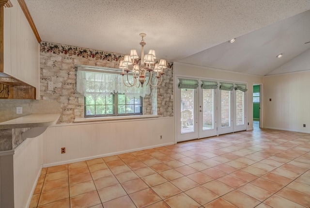 414 Daffodil St, Lake Jackson, TX 77566 - unfurnished dining area featuring healthy amount of natural light, light tile patterned floors, a chandelier, a textured ceiling, and vaulted ceiling