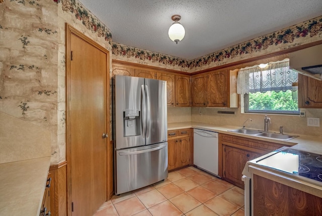414 Daffodil St, Lake Jackson, TX 77566 - kitchen featuring stainless steel refrigerator with ice dispenser, white dishwasher, brown cabinetry, stove, and light countertops