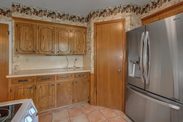414 Daffodil St, Lake Jackson, TX 77566 - kitchen featuring stainless steel fridge, light countertops, brown cabinets, a textured ceiling, and stove