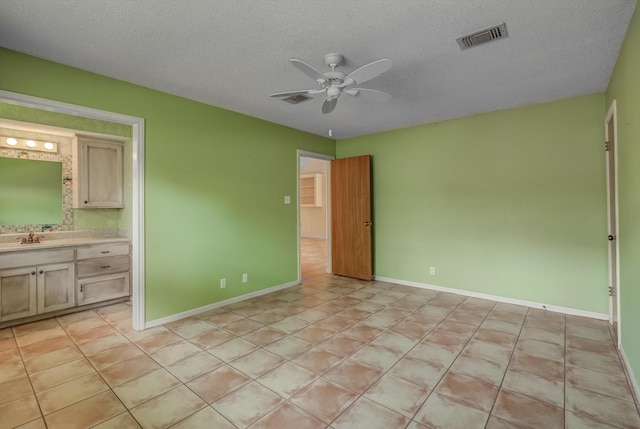 414 Daffodil St, Lake Jackson, TX 77566 - unfurnished bedroom featuring a textured ceiling, a ceiling fan, light tile patterned floors, and ensuite bathroom