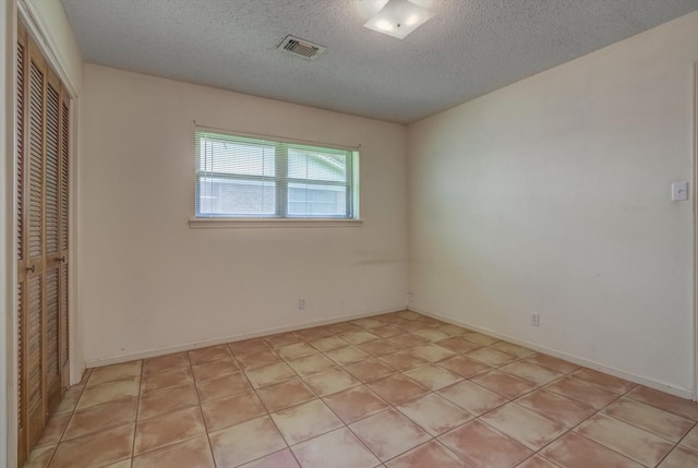 414 Daffodil St, Lake Jackson, TX 77566 - unfurnished bedroom with a textured ceiling, a closet, and light tile patterned flooring