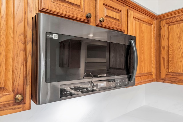 7331 Hazel Cove Dr, Houston, TX 77095 - kitchen view of stainless steel microwave, brown cabinetry, and light countertops