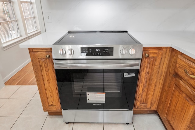7331 Hazel Cove Dr, Houston, TX 77095 - kitchen view of stainless steel electric range oven, brown cabinetry, and light countertops