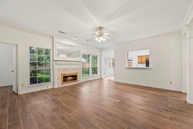 7331 Hazel Cove Dr, Houston, TX 77095 - unfurnished living room featuring healthy amount of natural light, a ceiling fan, crown molding, a fireplace, and a textured ceiling