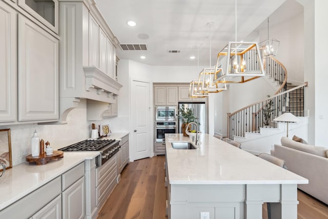 21514 Sunny Riverbank Cir, Cypress, TX 77433 - kitchen featuring appliances with stainless steel finishes, a chandelier, wood finished floors, an island with sink, and open floor plan
