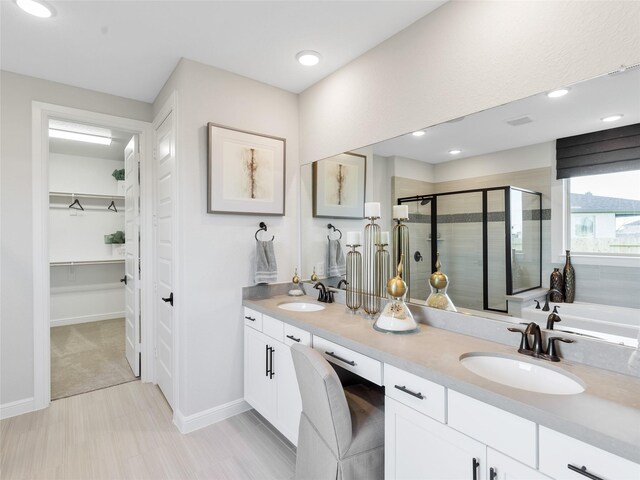 9227 Heckenberg Arbor Ln, Cypress, TX 77433 - bathroom featuring a spacious closet, a stall shower, double vanity, and recessed lighting