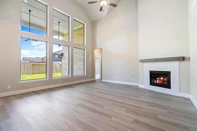 916 Wormwood Dr, League City, TX 77573 - unfurnished living room featuring a ceiling fan, a fireplace, wood finished floors, and high vaulted ceiling