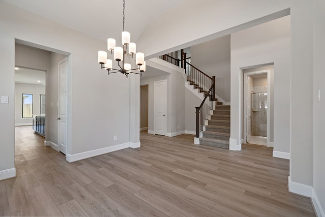 916 Wormwood Dr, League City, TX 77573 - unfurnished dining area with stairs, light wood-style floors, a chandelier, and vaulted ceiling