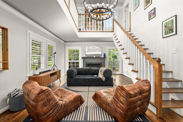 208 W 34th St, Houston, TX 77018 - living room featuring wood finished floors, stairway, crown molding, a chandelier, and a high ceiling