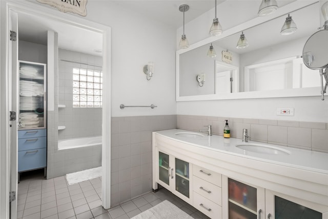 208 W 34th St, Houston, TX 77018 - full bathroom featuring tile patterned flooring, double vanity, a relaxing tiled tub, and tile walls