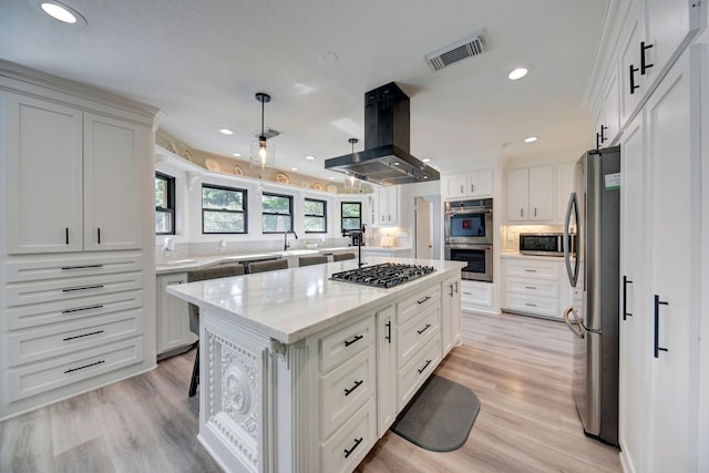 1950 Country Club Rd, Brenham, TX 77833 - kitchen with stainless steel appliances, island exhaust hood, a kitchen island, white cabinetry, and recessed lighting