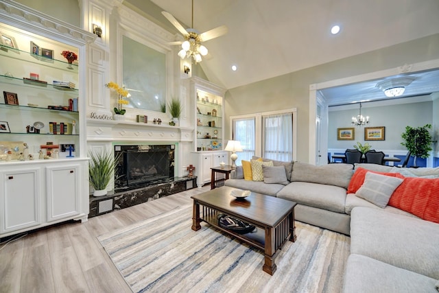 1950 Country Club Rd, Brenham, TX 77833 - living area with light wood finished floors, a high end fireplace, a chandelier, ceiling fan, and built in features