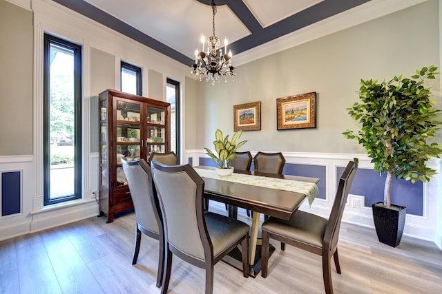 1950 Country Club Rd, Brenham, TX 77833 - dining space with a chandelier, a decorative wall, light wood-style flooring, plenty of natural light, and a wainscoted wall