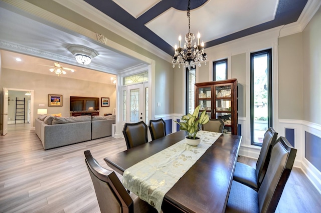 1950 Country Club Rd, Brenham, TX 77833 - dining space with a chandelier, plenty of natural light, light wood finished floors, ornamental molding, and wainscoting