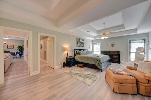 1950 Country Club Rd, Brenham, TX 77833 - bedroom with a tray ceiling, multiple windows, light wood-type flooring, and ceiling fan