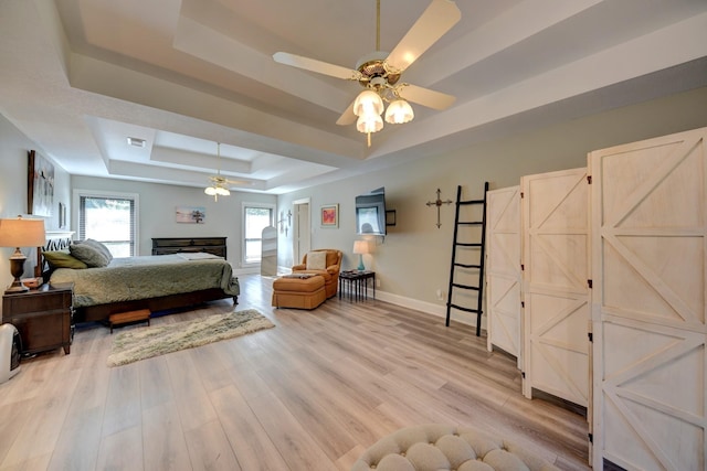 1950 Country Club Rd, Brenham, TX 77833 - bedroom with a tray ceiling, light wood-type flooring, and a ceiling fan