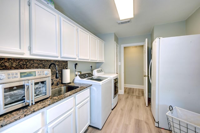 1950 Country Club Rd, Brenham, TX 77833 - laundry area featuring washing machine and clothes dryer and light wood-type flooring