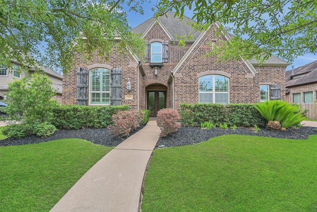 1107 Rymers Switch Ln, Friendswood, TX 77546 - view of front of home featuring french doors, brick siding, a front lawn, and a shingled roof