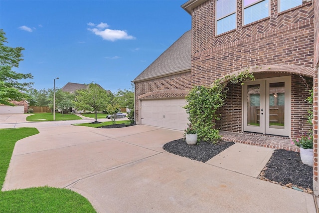1107 Rymers Switch Ln, Friendswood, TX 77546 - view of property exterior featuring brick siding, french doors, concrete driveway, an attached garage, and a shingled roof