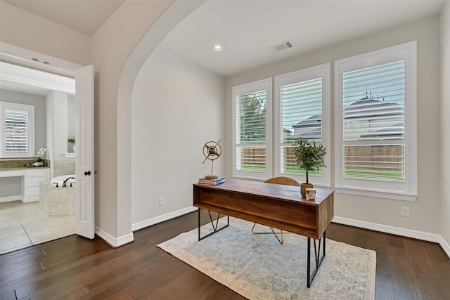 1107 Rymers Switch Ln, Friendswood, TX 77546 - home office featuring arched walkways, plenty of natural light, dark wood-style floors, and recessed lighting