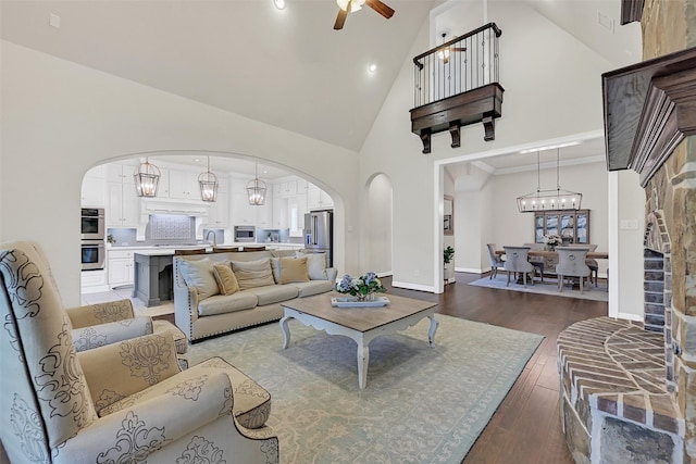 1107 Rymers Switch Ln, Friendswood, TX 77546 - living room featuring arched walkways, high vaulted ceiling, hardwood / wood-style flooring, a ceiling fan, and a chandelier