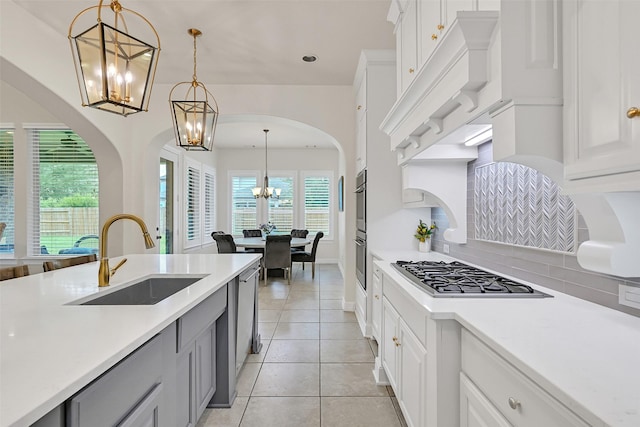 1107 Rymers Switch Ln, Friendswood, TX 77546 - kitchen featuring a chandelier, appliances with stainless steel finishes, light countertops, light tile patterned floors, and decorative light fixtures