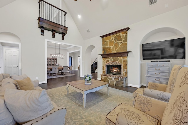 1107 Rymers Switch Ln, Friendswood, TX 77546 - living room with high vaulted ceiling, arched walkways, wood finished floors, and a stone fireplace