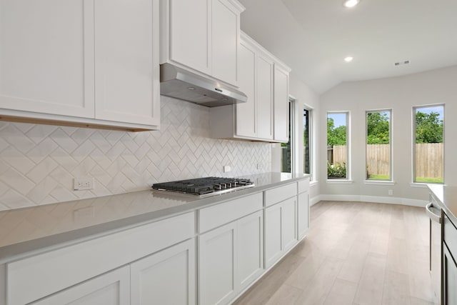 910 Hooks Trl, League City, TX 77573 - kitchen with stainless steel gas stovetop, under cabinet range hood, backsplash, light countertops, and white cabinets