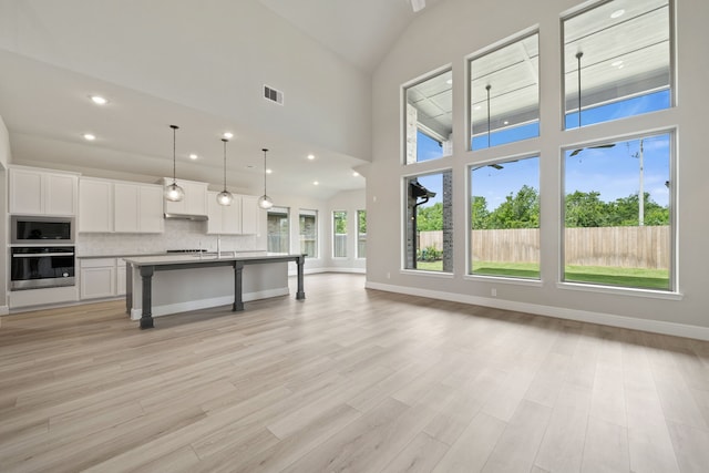 910 Hooks Trl, League City, TX 77573 - kitchen with appliances with stainless steel finishes, open floor plan, white cabinetry, a breakfast bar area, and recessed lighting