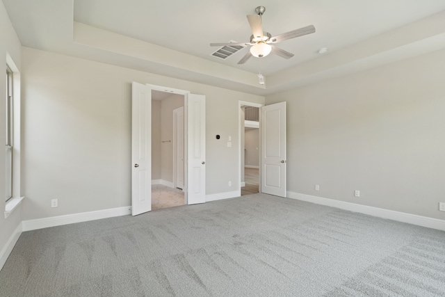 910 Hooks Trl, League City, TX 77573 - unfurnished bedroom featuring carpet flooring, a tray ceiling, and ceiling fan