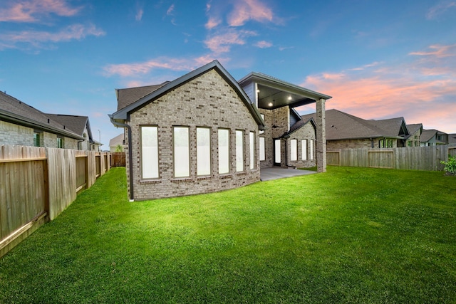 910 Hooks Trl, League City, TX 77573 - back of house at dusk featuring a fenced backyard and brick siding
