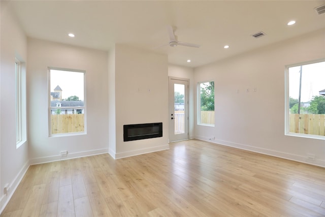 510 E 37th St, Houston, TX 77022 - unfurnished living room with plenty of natural light, light wood-style flooring, a glass covered fireplace, ceiling fan, and recessed lighting