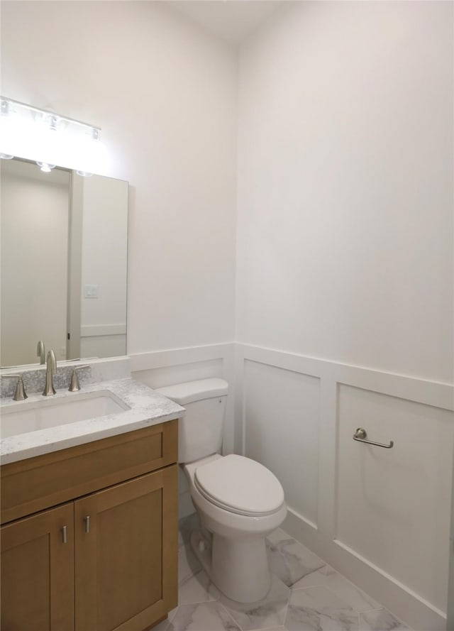510 E 37th St, Houston, TX 77022 - half bathroom with marble look tiles, vanity, and a wainscoted wall