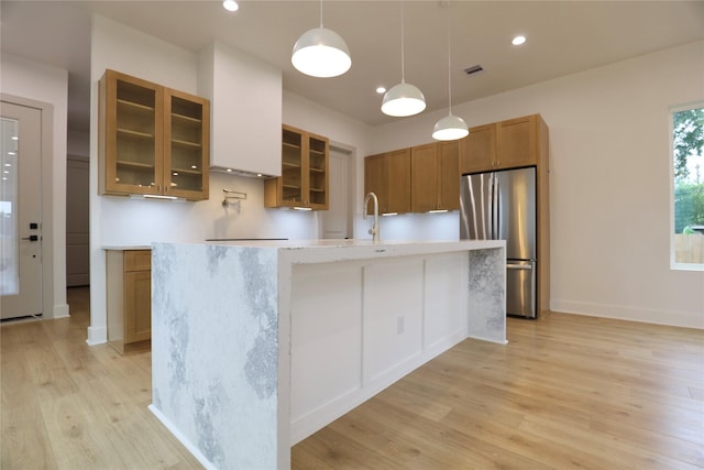 510 E 37th St, Houston, TX 77022 - kitchen featuring freestanding refrigerator, light wood finished floors, light countertops, brown cabinets, and an island with sink